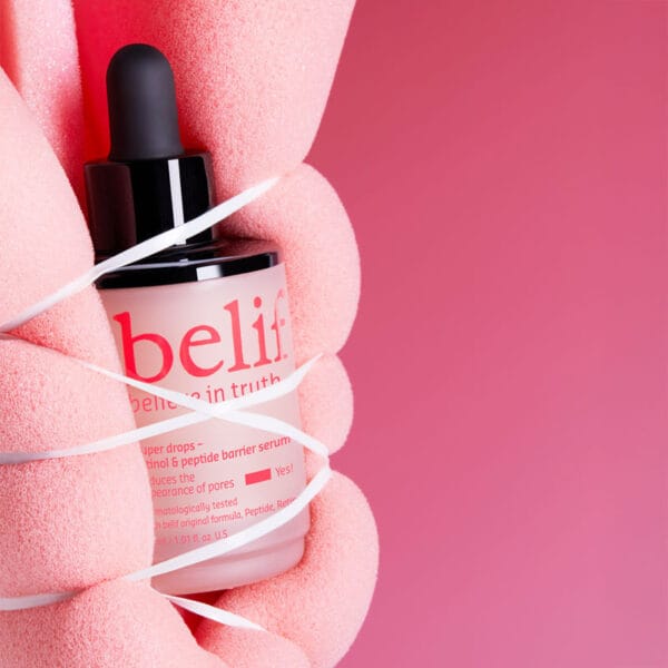 belif Super Drops Retinol & Peptide Barrier Serum 30ml - Sérum anti-âge pour une peau plus ferme, des pores resserrés & une barrière cutanée renforcée. Image Eponge liée autour du produit.